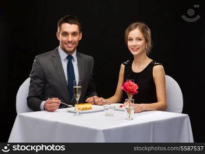 restaurant, couple and holiday concept - smiling couple eating dessert at restaurant