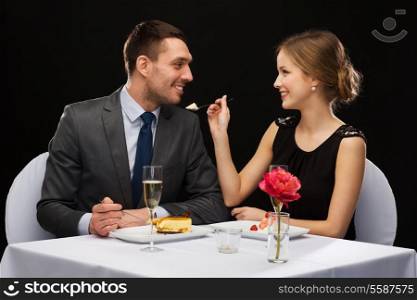 restaurant, couple and holiday concept - smiling couple eating dessert at restaurant