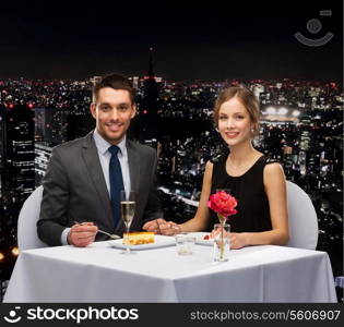 restaurant, couple and holiday concept - smiling couple eating dessert at restaurant