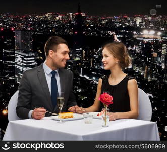 restaurant, couple and holiday concept - smiling couple eating dessert at restaurant