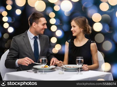 restaurant, couple and holiday concept - smiling couple eating main course at restaurant