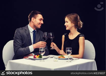 restaurant, couple and holiday concept - smiling couple eating main course with red wine at restaurant