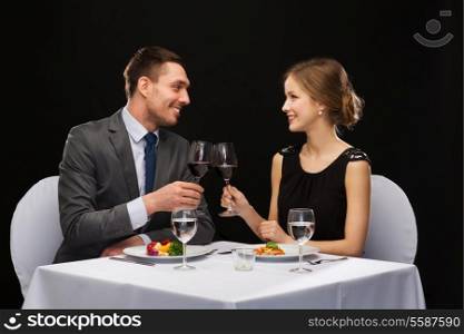 restaurant, couple and holiday concept - smiling couple eating main course with red wine at restaurant
