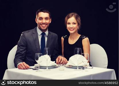 restaurant, couple and holiday concept - smiling couple holding hands at restaurant