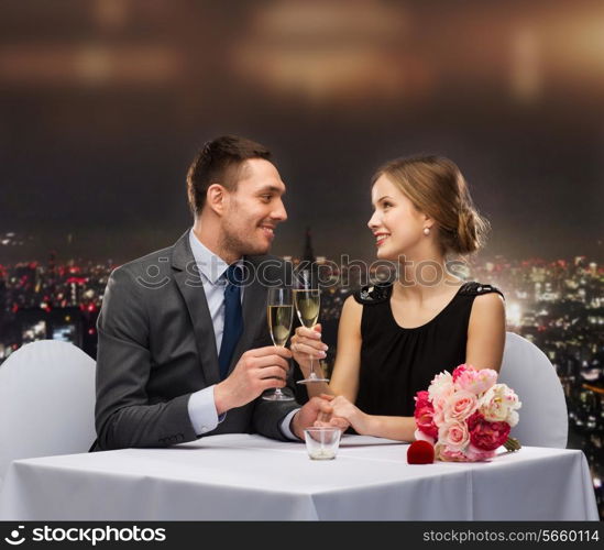 restaurant, couple and holiday concept - smiling couple with glass of champagne looking at each other at restaurant