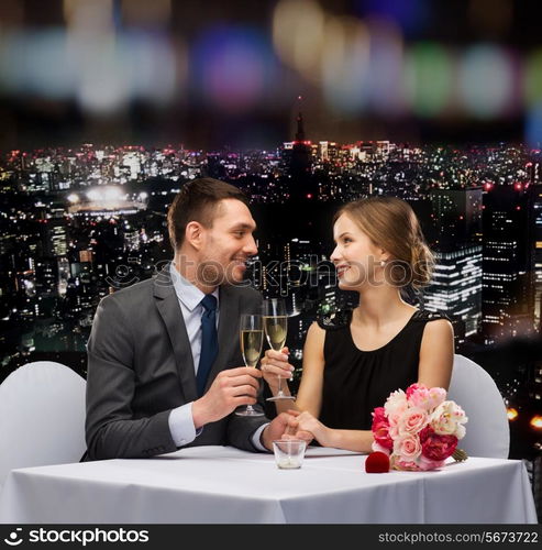 restaurant, couple and holiday concept - smiling couple with glass of champagne looking at each other at restaurant