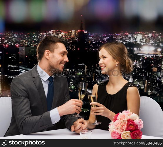 restaurant, couple and holiday concept - smiling couple with glass of champagne looking at each other at restaurant