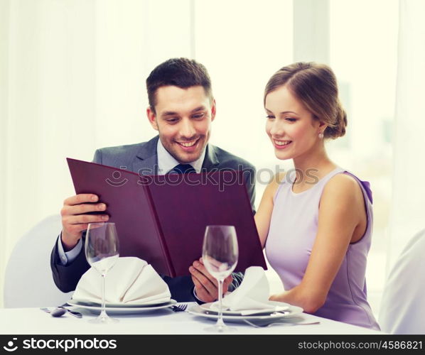 restaurant, couple and holiday concept - smiling couple with menu at restaurant