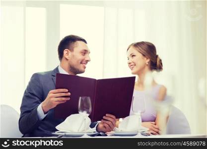restaurant, couple and holiday concept - smiling couple with menu at restaurant