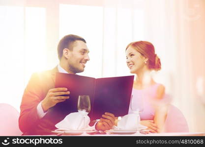 restaurant, couple and holiday concept - smiling couple with menu at restaurant