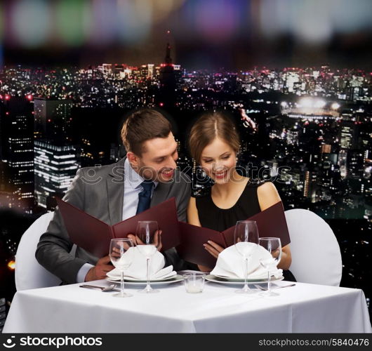 restaurant, couple and holiday concept - smiling couple with menus at restaurant