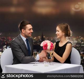 restaurant, couple and holiday concept - smiling man giving flower bouquet to woman at restaurant