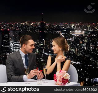 restaurant, couple and holiday concept - smiling man proposing to his girlfriend at restaurant