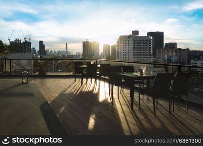 Restaurant dining table and view of business building on terrace at sunny afternoon time