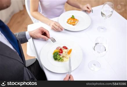 restaurant, food, people, date and holiday concept - close up of couple eating appetizers at restaurant