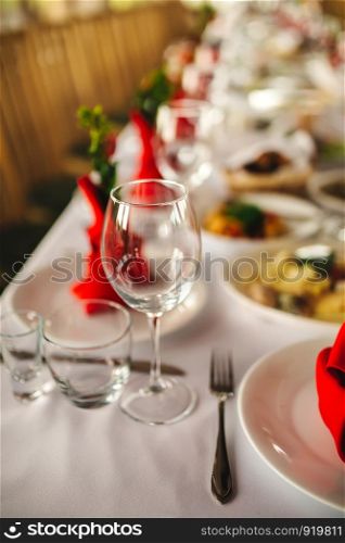 Restaurant interior, serving, wine and water glasses, plates, forks and knives on textile napkins stand in row on vintage gray wooden table. Concept banquet, birthday, conference, group lunch. Restaurant interior, serving, wine and water glasses, plates. Concept banquet, birthday, conference, group lunch