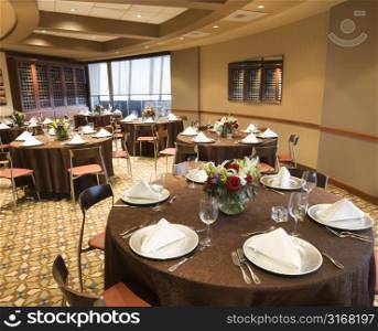 Restaurant interior with table setting and chairs.