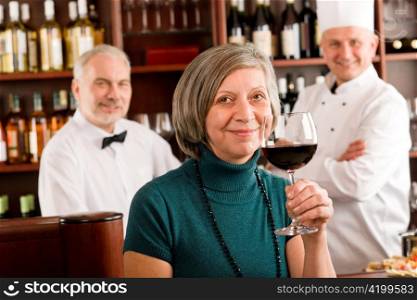 Restaurant manager happy taste glass of red wine in bar