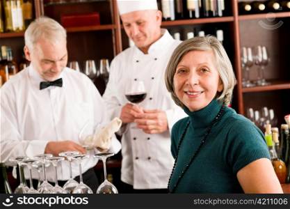 Restaurant manager smiling with staff at wine bar