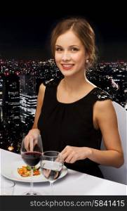 restaurant, people and holiday concept - smiling young woman eating main course at restaurant