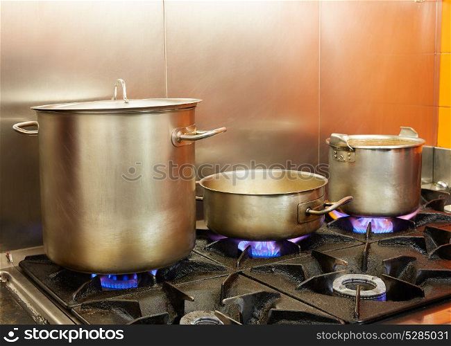 Restaurant pro kitchen with stainless steel pans in fire