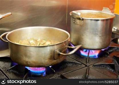 Restaurant pro kitchen with stainless steel pans in fire