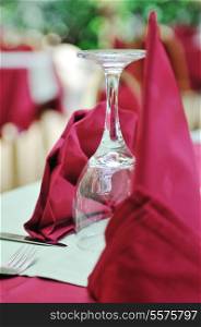 restaurant table with empty wine glass and red table decoration
