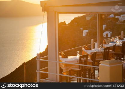 restaurant tables by the sea at sunset