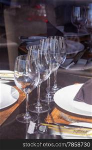 restaurant tables with silverware and glasses ready for a lunch or dinner