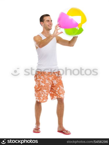 Resting on vacation happy young man playing with beach ball