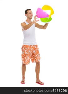 Resting on vacation happy young man playing with beach ball