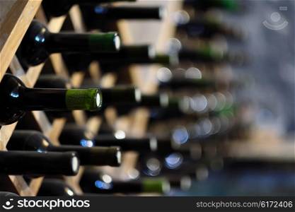 Resting wine bottles stacked on wooden racks in cellar
