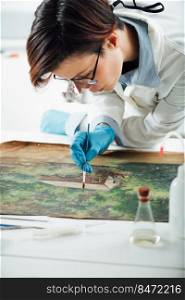 Restoring old oil painting, conservator removing varnish from an oil painting. Restoring Old Oil Painting