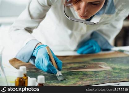 Restoring old oil painting, conservator removing varnish from an oil painting. Restoring Old Oil Painting