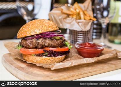 Restourant serving dish - burger with cutlet with frying potato on wooden board
