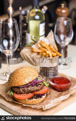 Restourant serving dish - burger with cutlet with frying potato on wooden board