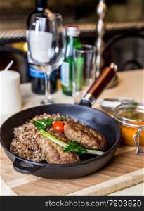 Restourant serving dish - cutlet with buckwheat on wooden board