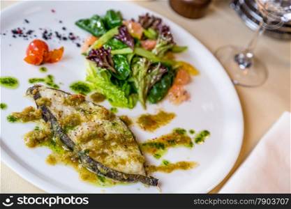 Restourant serving dish - roast slice fish on table
