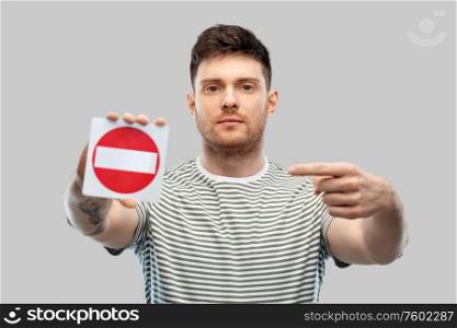 restriction and traffic concept - young man showing stop sign. young man showing stop sign