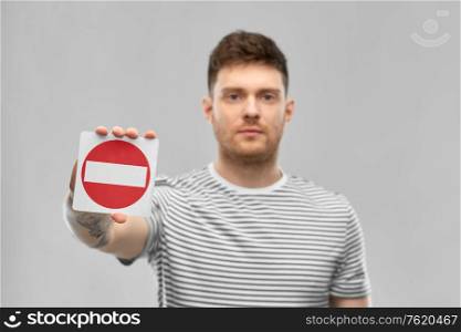 restriction and traffic concept - young man showing stop sign. young man showing stop sign