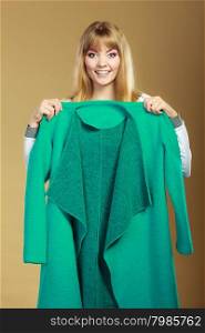 Retail and sale. Blonde girl fashionable woman buying clothes. Client customer showing green coat