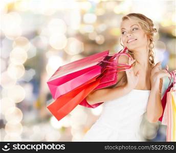 retail and sale concept - elegant woman in dress with shopping bags