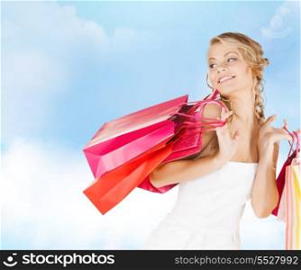 retail and sale concept - elegant woman in dress with shopping bags