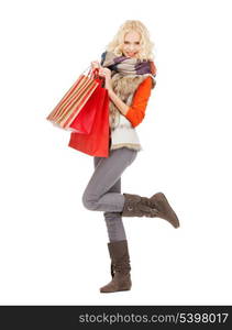 retail and sale concept - happy teenage girl in winter clothes with shopping bags