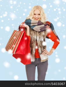 retail and sale concept - happy teenage girl in winter clothes with shopping bags