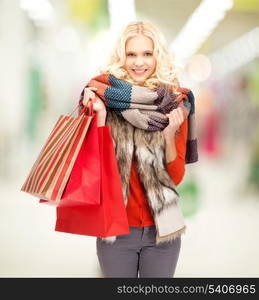 retail and sale concept - happy teenage girl in winter clothes with shopping bags