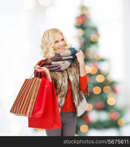 retail and sale concept - happy teenage girl in winter clothes with shopping bags