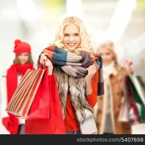 retail and sale concept - happy teenage girls in winter clothes with shopping bags