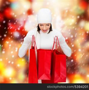 retail and sale concept - happy woman in winter clothes looking into shopping bags