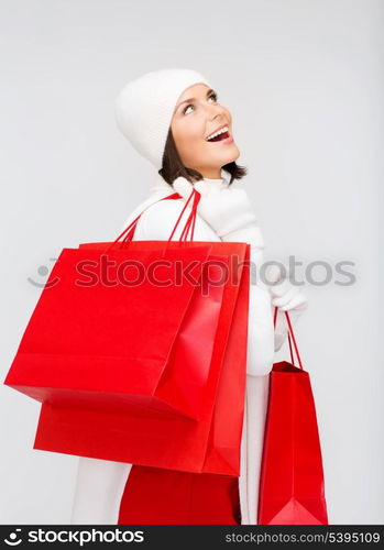 retail and sale concept - happy woman in winter clothes with shopping bags